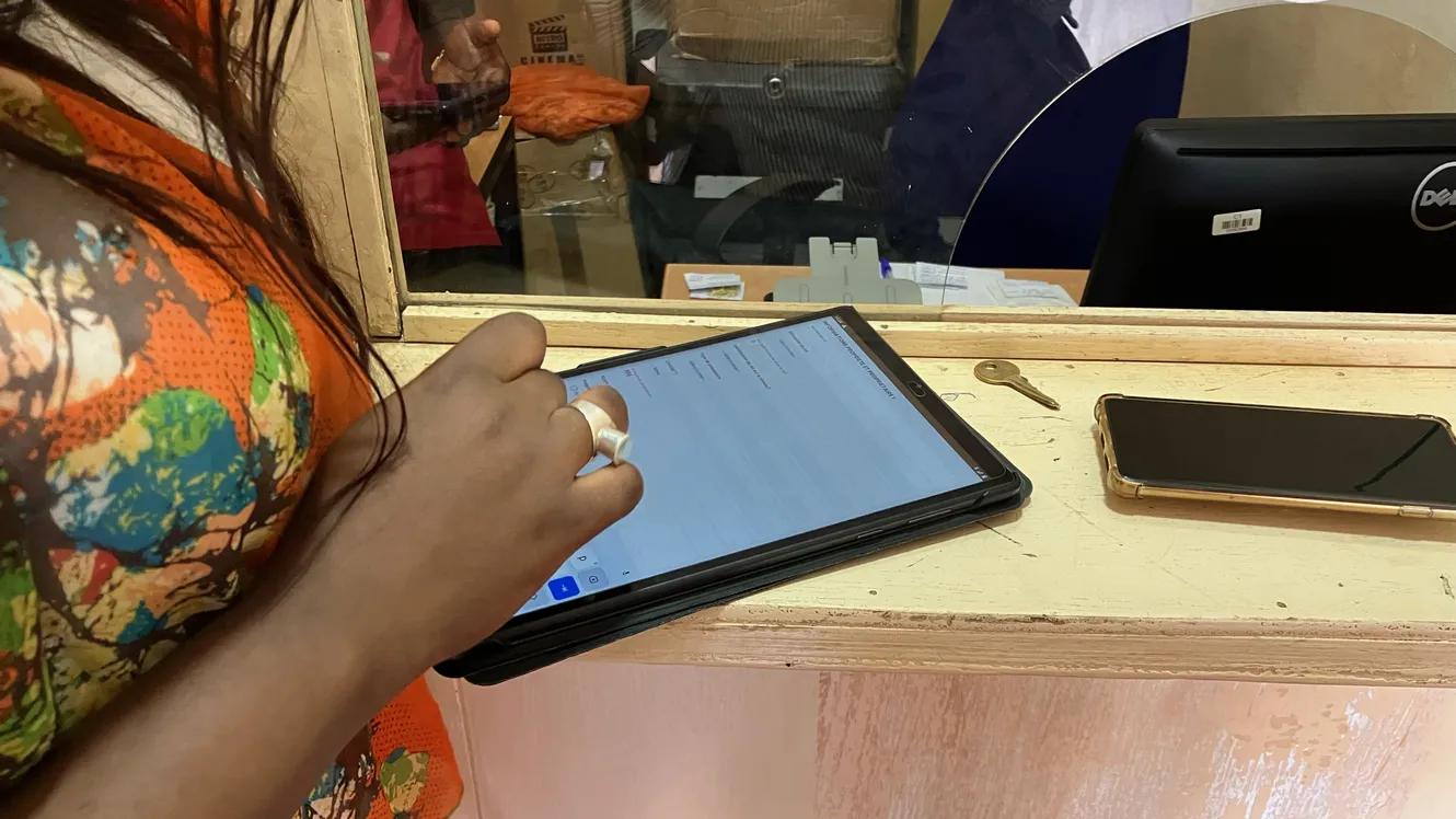 Main d'une femme qui tape sur une tablette numérique
