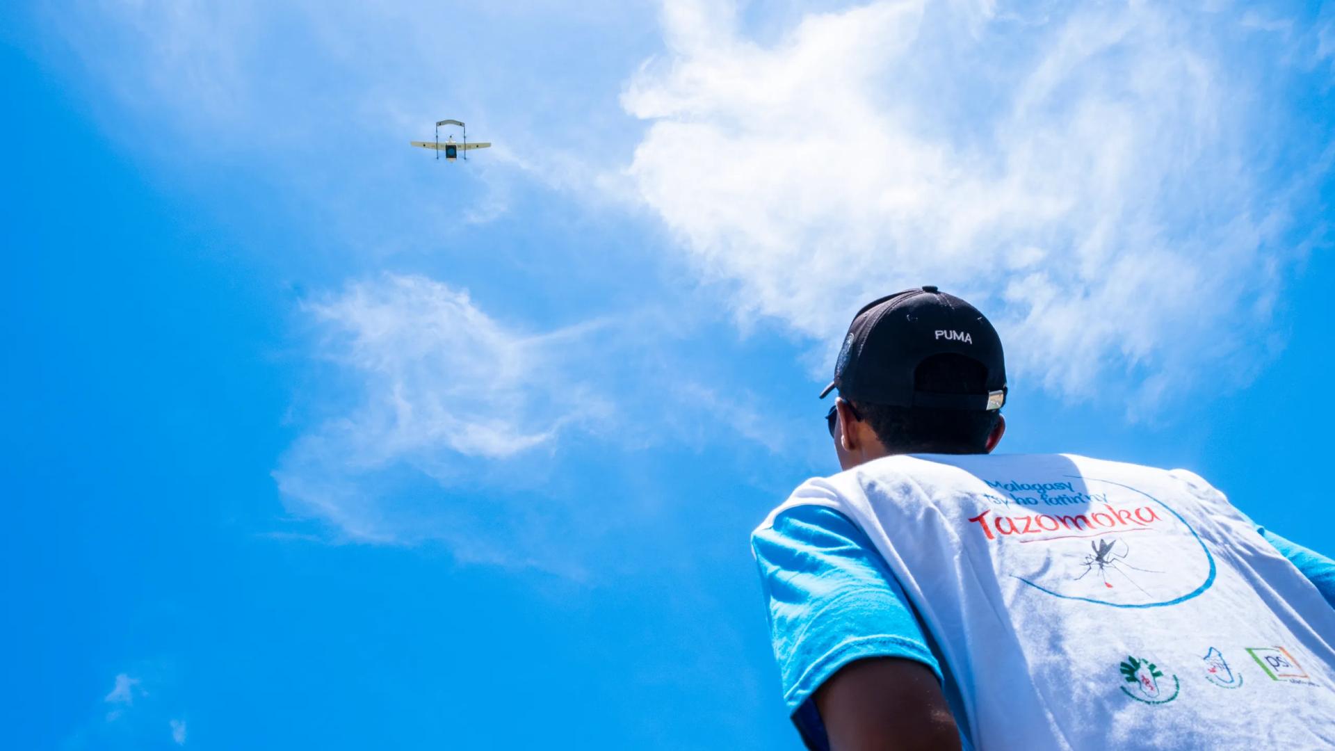 Homme qui regarde un drone dans le ciel